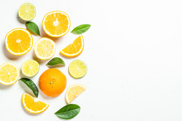 Citrus fruits at white background. Orange, lemon, lime with green leaves. Top view with copy space.