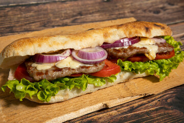Beef kebabs served with melted cheese and salad in bread on wooden board