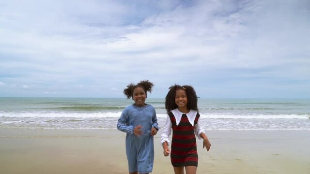slow motion, african-American children  running on the beach in the summer
