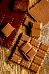 black and milk chocolate bars with mint dark wooden table background top view