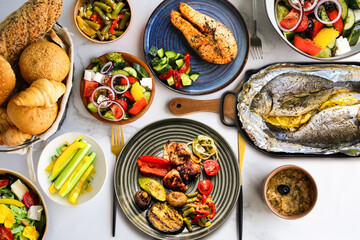 Lots of healthy food top view.Proper nutrition.Table with food on plates, top view. Healthy food plates top view.Assorted buffet.Healthy dinner.Salmon steak with salad, grilled vegetables and meat on 