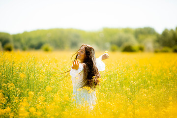 Young woman in the rapeseed field - Powered by Adobe