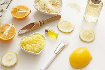 Natural cosmetic products for the body with vitamin C, top view, flat lay. Citrus fruits, bottles with cosmetics, sea salt, scrab, plastics of lemons, oranges, limes, spices, herbs, oils