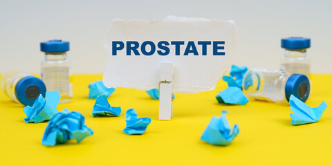 On a yellow background are ampoules, blue crumpled paper and paper with the inscription - PROSTATE