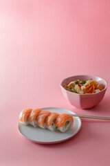 sushi roll Philadelphia on a plate on a pink background. Delicious fresh roll with curd cheese,...