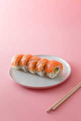 
sushi roll Philadelphia on a plate on a pink background. Delicious fresh roll with curd cheese,...