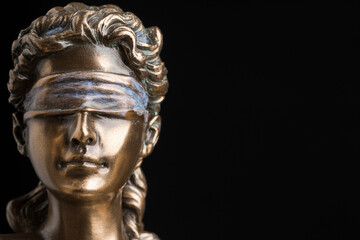 Portrait of the blindfolded goddess of justice Themis isolated on black background with copy space,...
