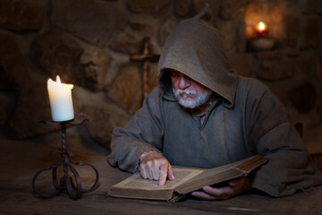 Medieval monk studies the Bible - obrazy, fototapety, plakaty