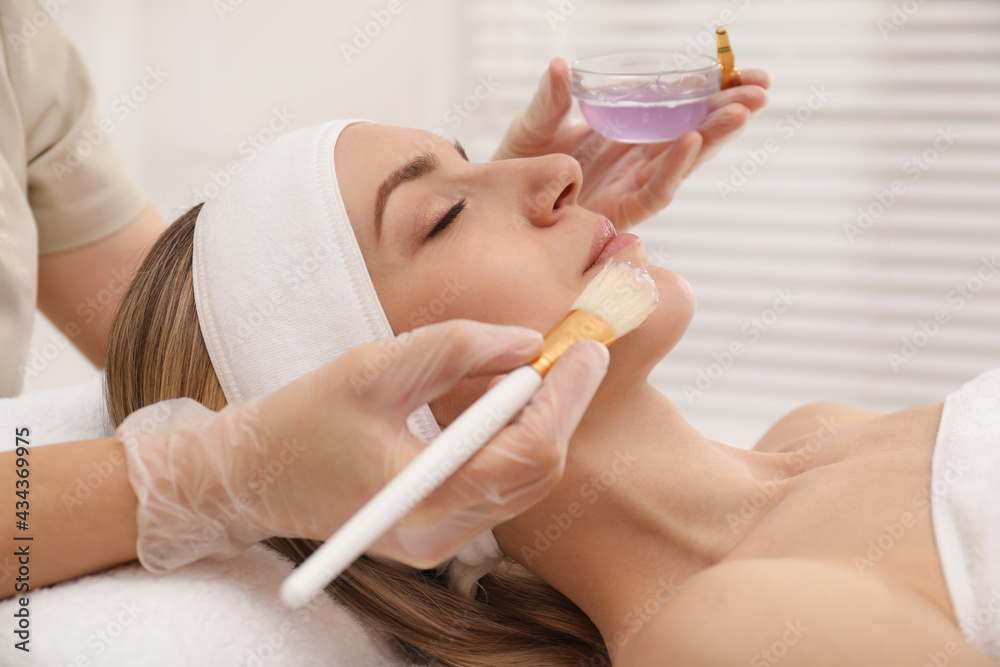 Sticker Young woman during face peeling procedure in salon