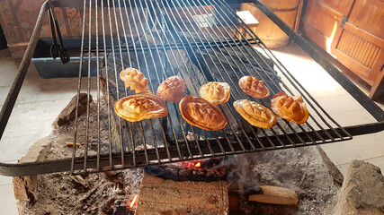 A smoked cheese made of salted sheep milk exclusively in the Tatra Mountains, Poland (oscypek) getting grilled on a barbecue. The cheese starts melting. Traditional mountain snack. Delicasy.