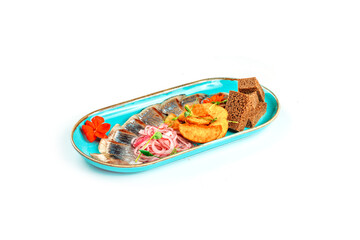 Pieces of pickled herring with onions, baked potatoes and slices of bread on a blue plate, on a white background, isolated
