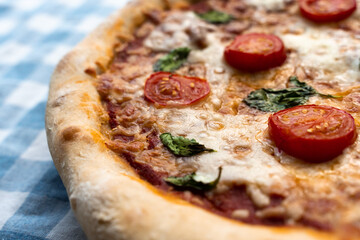Pizza margherita on the blue tablecloth. 