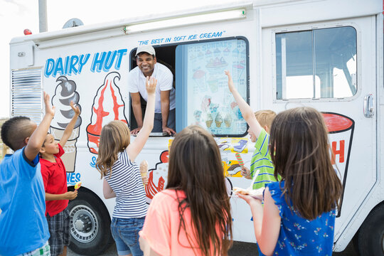 Group of children waving at man in ice cream truck