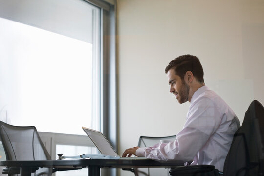 Side View Of Male Doctor Using Laptop