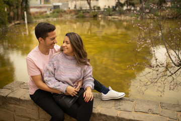 A couple in a romantic moment smiling and hugging in a park