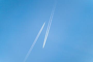 Two aircrafts narrowly miss each other in the clear, blue sky.