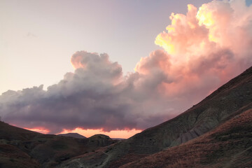 Obraz premium A big cloud over mountains at sunset in an autumn evening