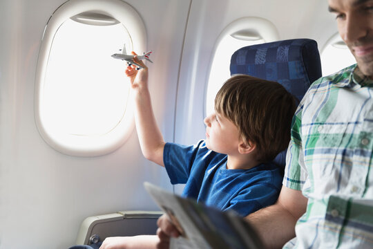 Boy playing with toy plane in airplane