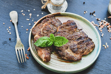 Grilled juicy pork steak, BBQ dishes on black background with copy space. Top view, flat lay food