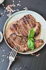 Grilled juicy pork steak, BBQ dishes on black background with copy space. Top view, flat lay food