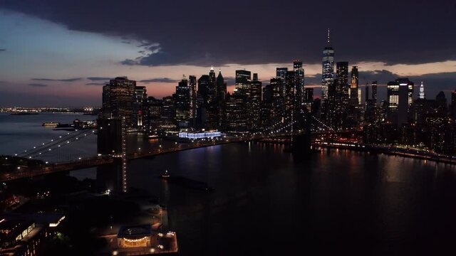 evening view of downtown NYC flying backwards over Manhattan Bridge