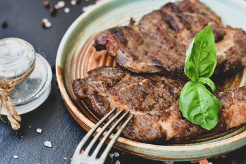 Grilled juicy pork steak, BBQ dishes on black background with copy space. Top view, flat lay food