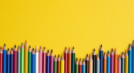 Colouring pencils isolated on yellow background close up concept with copy space for text 