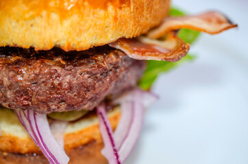 freshly prepared hamburger with tomato salad sauce and pickled cucumbers