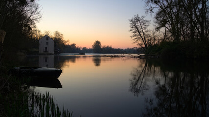 Lever de soleil sur le Loir proche de la Flèche avec une barque en mouvement au premier plan