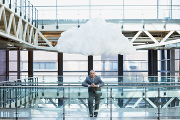 Obraz na płótnie Canvas Portrait businessman with cloud overhead on atrium balcony