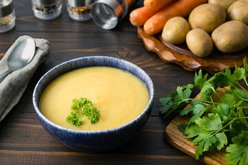Freshly cooked potato soup in a bowl garnished with parsley and ingredients and spoon around