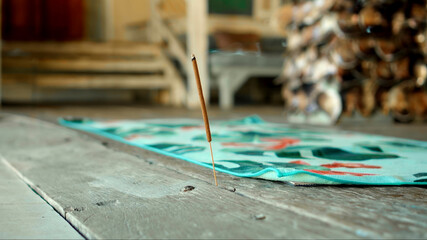 Smoky aroma stick standing on a wooden antique floor