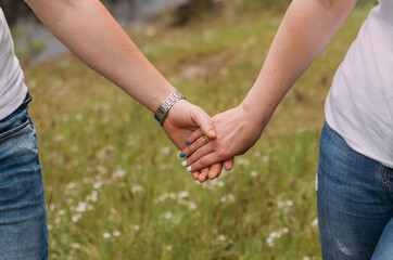 loving couple holding hands close up on blurred background