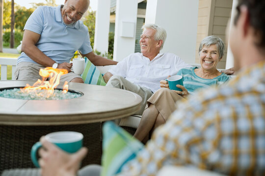Happy family and friends having coffee around fire pit table