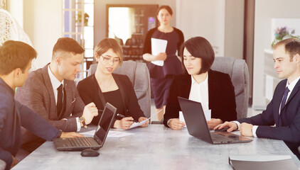 Group of young successful businessmen lawyers communicating together in a conference room while working on a project