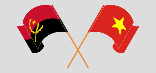 Crossed and waving flags of Angola and Vietnam