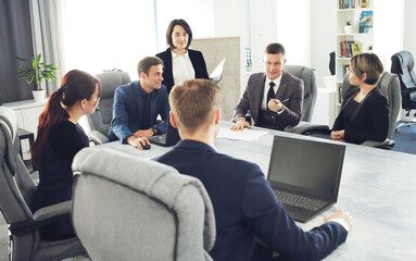 Group of young successful businessmen lawyers communicating together in a conference room while working on a project