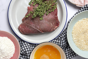 Preparation of traditional Milanese escalope with flour, egg, breadcrumbs, cheese and ham