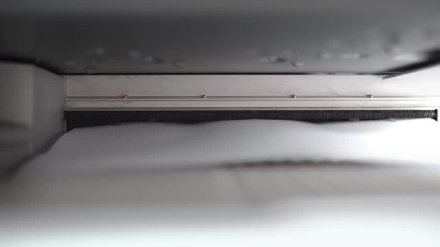 Closeup of aser jet printer printing A4 paper pages in a storehouse or a business office