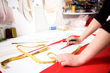 Fototapeta premium Tailor working with cloth at table in atelier.