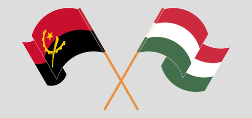 Crossed and waving flags of Angola and Hungary