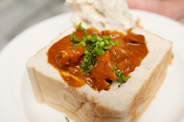 A traditional South African bunny chow, Indian curry served in a hollowed out loaf of bread.  Durban South Africa.