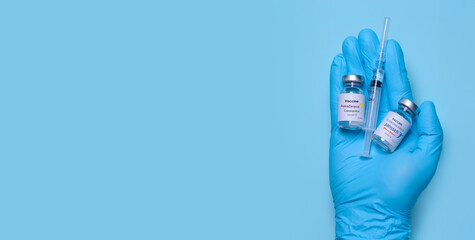 Kharkiv. Ukraine. January 9, 2021. Doctor's hand in gloves hold vials with coronavirus vaccine with AstraZeneca logo and Janssen johnson and johnson logo, syringe.Vaccination. Banner. Copy space