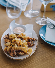 Porción de calamar frito estilo gourmet y una porción de croquetas de marisco en un restaurante de lujo
