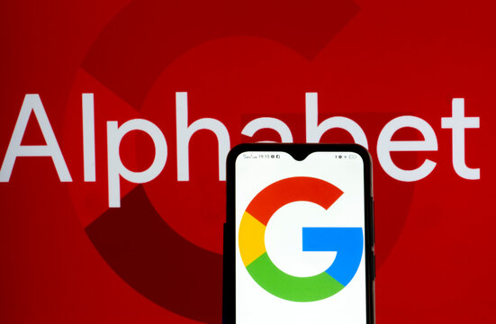 In this photo illustration Alphabet Inc. and Google logos seen displayed on a smartphone