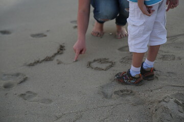 Mother and son playing in the sand at the beach