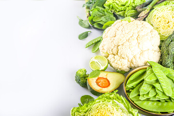 Healthy Diet Spring food background. Assortment of fresh raw organic green vegetables - broccoli, cauliflower, zucchini, cucumbers, asparagus, spinach, avocado, cabbage set on white background