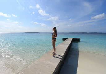 Obraz premium beautiful girl in bikini on the pier in the Maldives