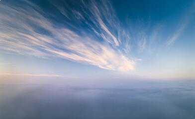 Fototapeta premium Beautiful warm sunrise over the puffy clouds. Above the cloudy sky. Drone footage. 