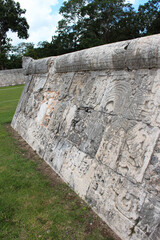 Fototapeta na wymiar Detail of Mayan wall carving on the territory of Chichen Itza, Yucatan, Mexico. Ancient Mayan stone reliefs at Chichen Itza ruins, mexican archaeological site.